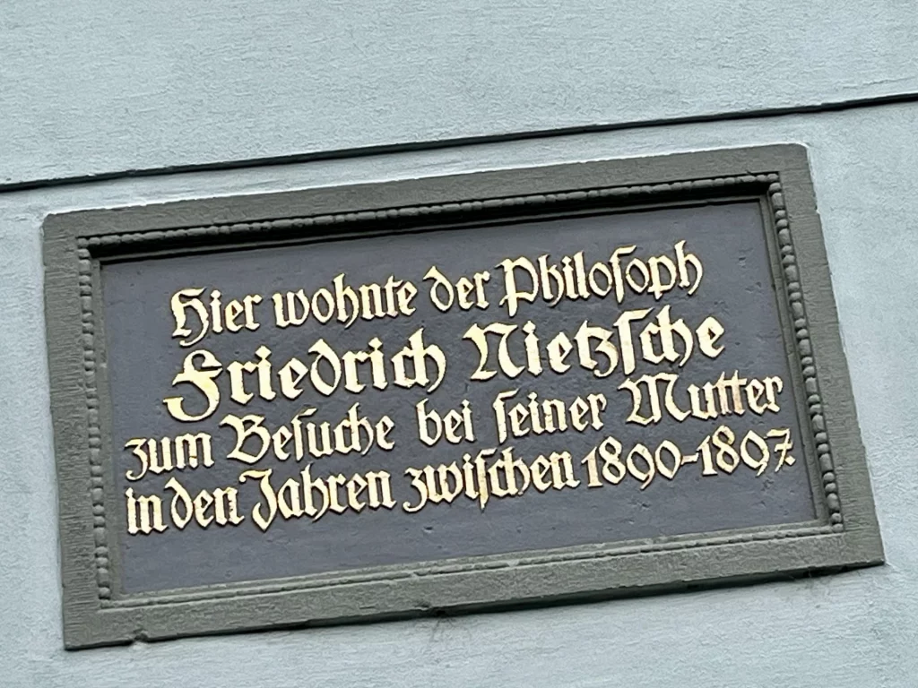 Nahaufnahme einer dunklen Gedenktafel mit goldener Frakturschrift: „Hier wohnte der Philosoph Friedrich Nietzsche zum Besuche bei seiner Mutter in den Jahren zwischen 1890–1897“.