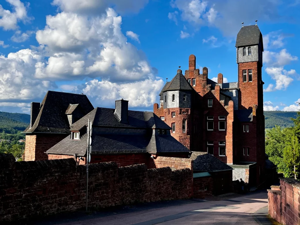Historisches Schloss mit Türmen und Zinnen aus rotem Sandstein. 