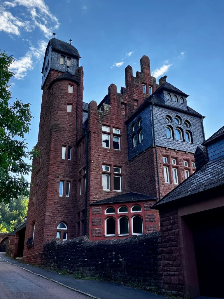 Hoher Burgturm mit Zinnen und Schieferdach. 