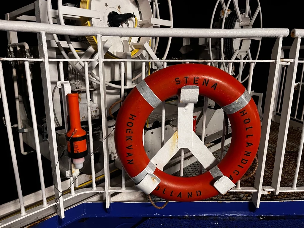 Ein klassischer oranger Rettungsring an der Reling mit der Aufschrift „Stena Hollandica“ und „Hoek van Holland“.