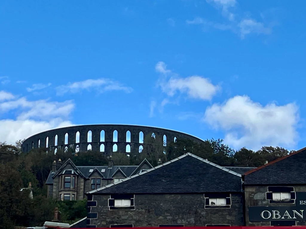 Die kreisförmige Granit-Ruine des McCaig's Tower mit ihren charakteristischen Rundbögen gegen den Himmel.