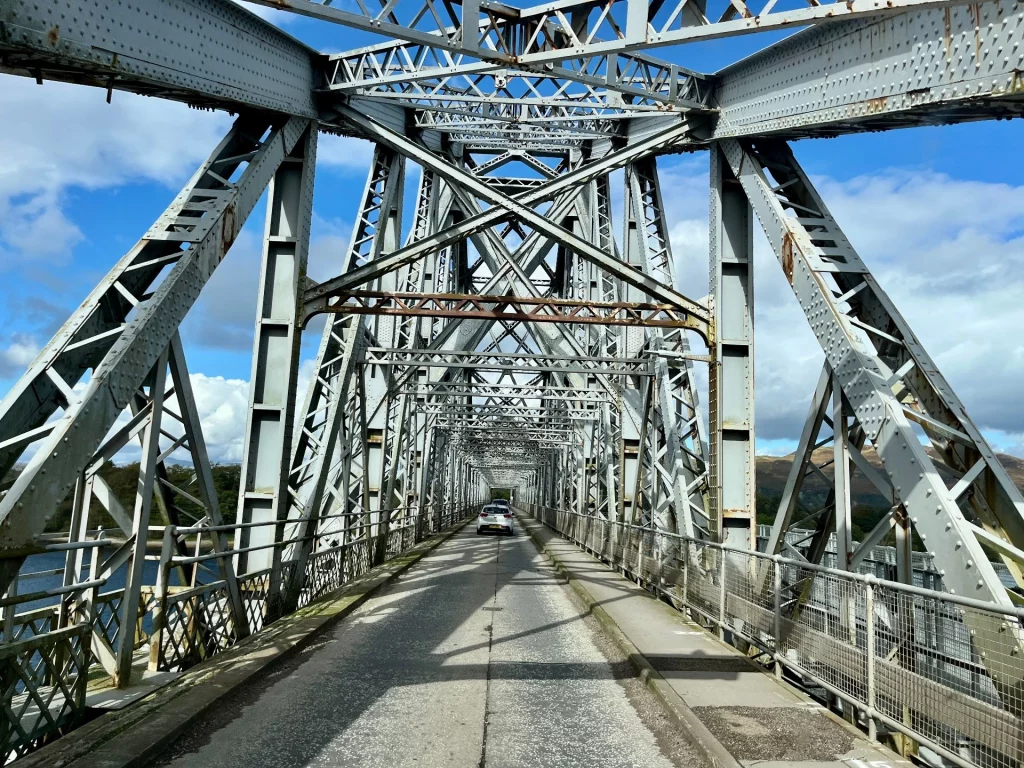 Ansicht der imposanten, grünen Auslegerbrücke aus Stahl, die sich über einen Meeresarm spannt.