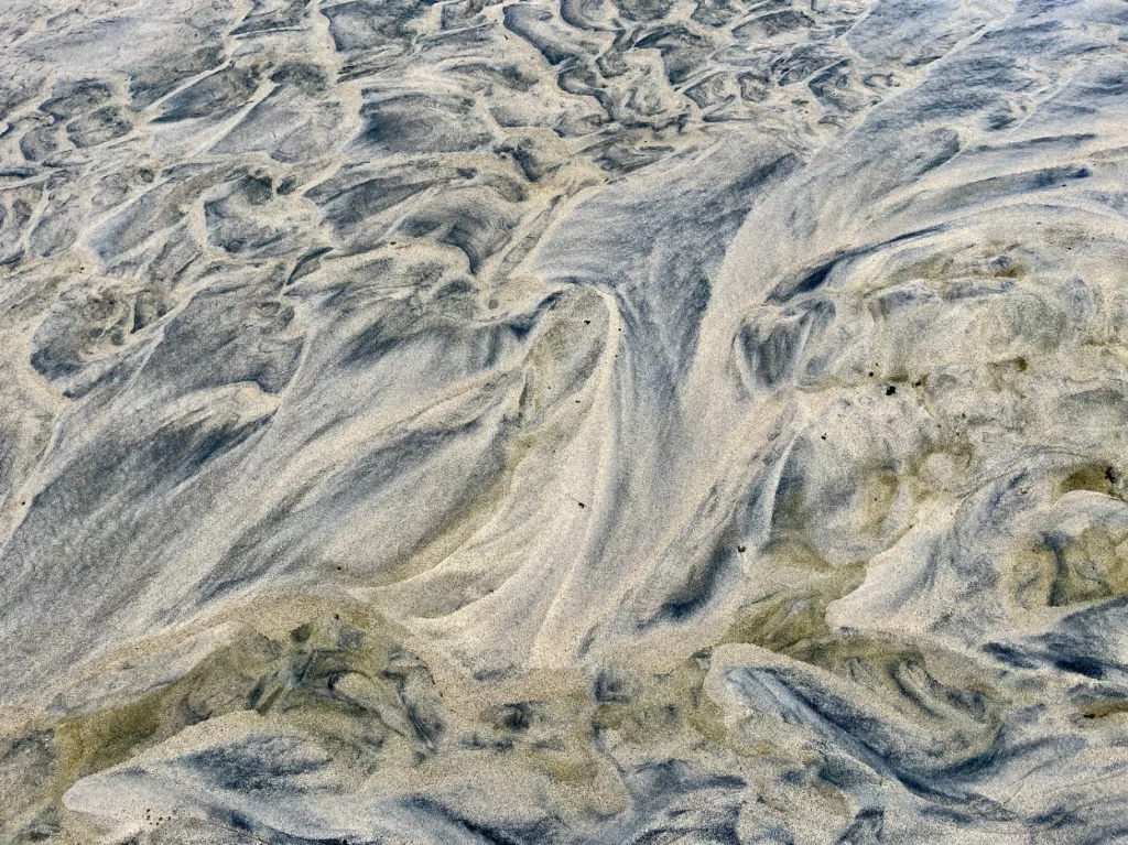 Detailaufnahme von wellenförmigen Sandstrukturen am Strand von Luskentyre, die durch Ebbe und Flut geformt wurden.