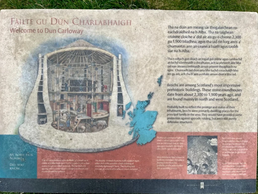 Eine bebilderte Tafel zeigt eine farbige Rekonstruktionszeichnung des Broch-Inneren sowie eine Karte von Schottland, auf der die Isle of Lewis markiert ist.