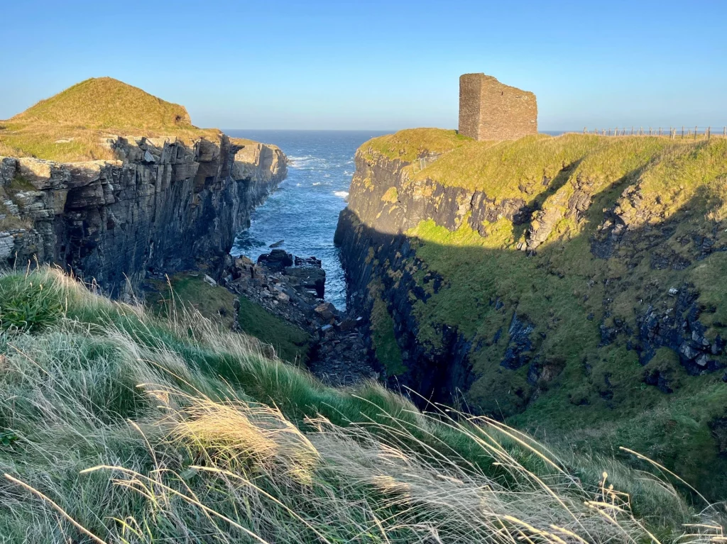 Nahansicht der steinernen Turmruine des Castle of Old Wick an der Küste von Caithness bei blauem Himmel.
