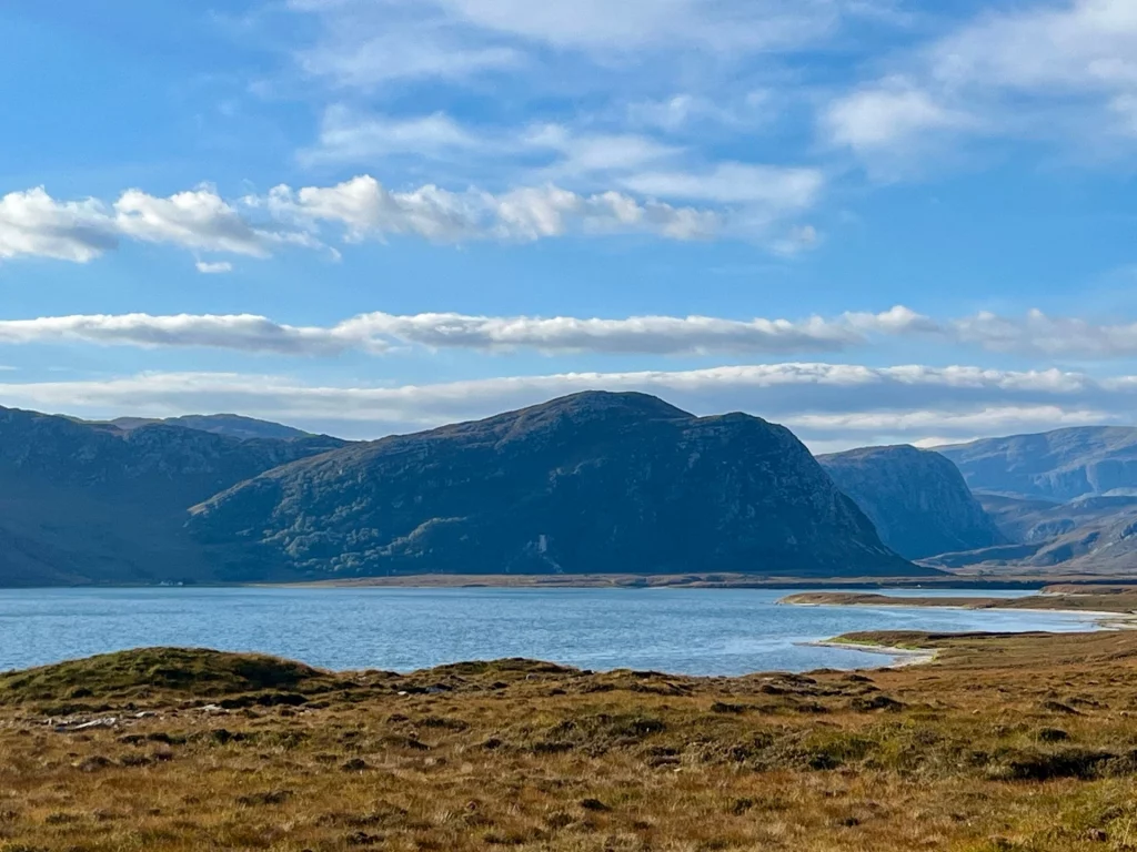 Weitläufiger Blick über das blaue Wasser von Loch Eriboll auf den markanten Berg Heilem unter einem leicht bewölkten Himmel in Sutherland, Schottland.