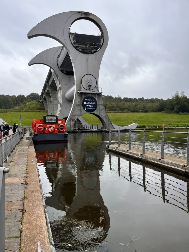 Blick aus dem unteren Kanalbecken nach oben auf das Falkirk Wheel Logo und die riesige Greifarm-Konstruktion.