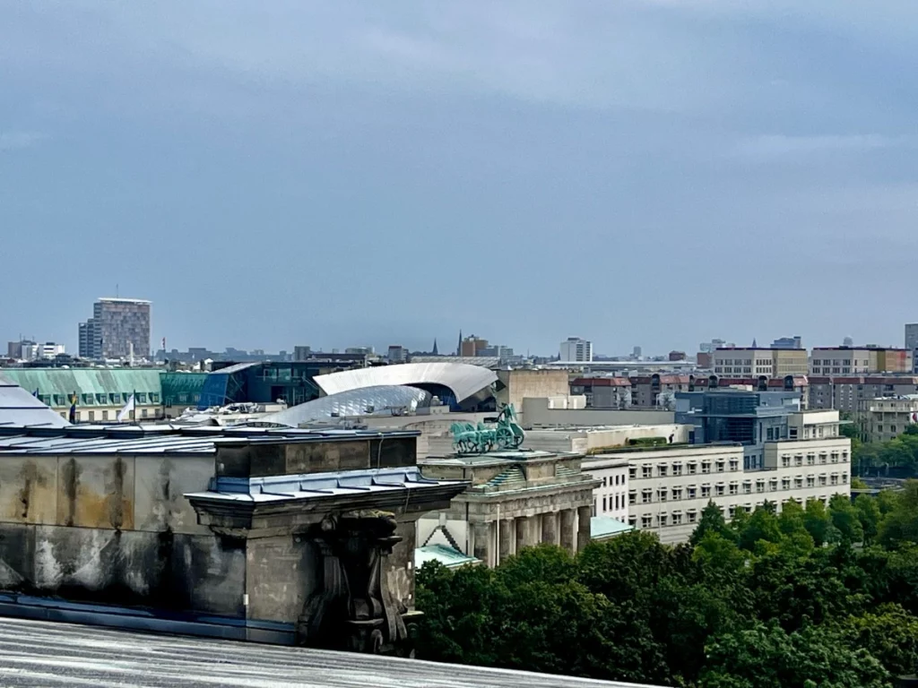 Berlin aus einer besonderen Perspektive: Von hier oben blickt man direkt auf das Brandenburger Tor und die markante Architektur rund um den Pariser Platz. Die Mischung aus historischen Denkmälern und modernen Fassaden prägt das Stadtbild und zeigt die pulsierende Energie der Hauptstadt, die sich bis zum Horizont erstreckt.