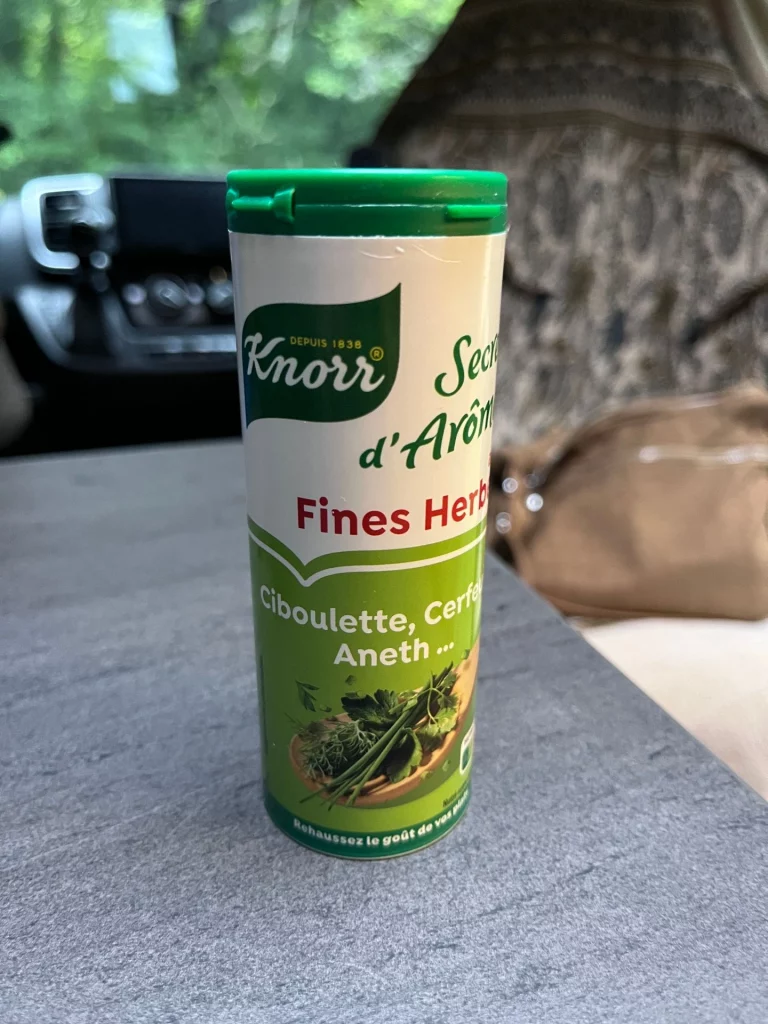 Ein Knorr Secret d'Arômes Fines Herbes Kräuterstreuer steht auf dem grauen Tisch im Innenraum des Kastenwagens.
