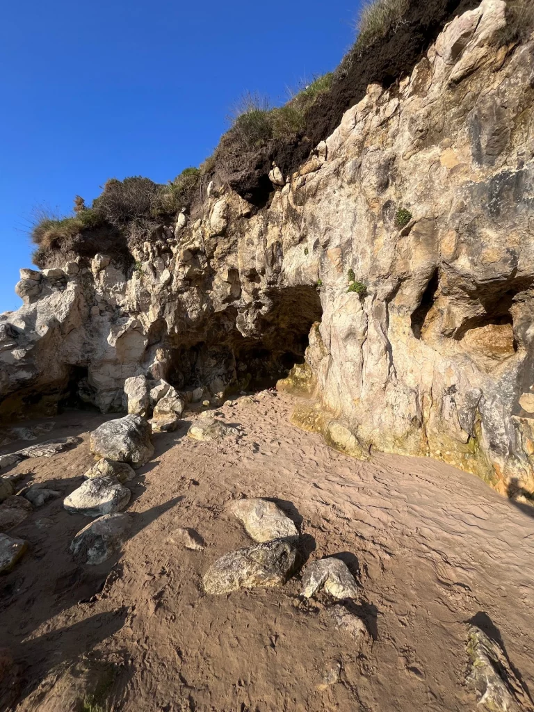 Imposante, zerklüftete Steilküste und Felsenhöhlen am Sandstrand nahe Santander an der Atlantikküste.