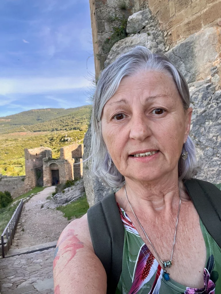 Karin Schmidtke steht verzweifelt blicken in einer gemauerten Ausbuchtung auf der hohen verschlossenen Festungsmauer des Castillo de Loarre.