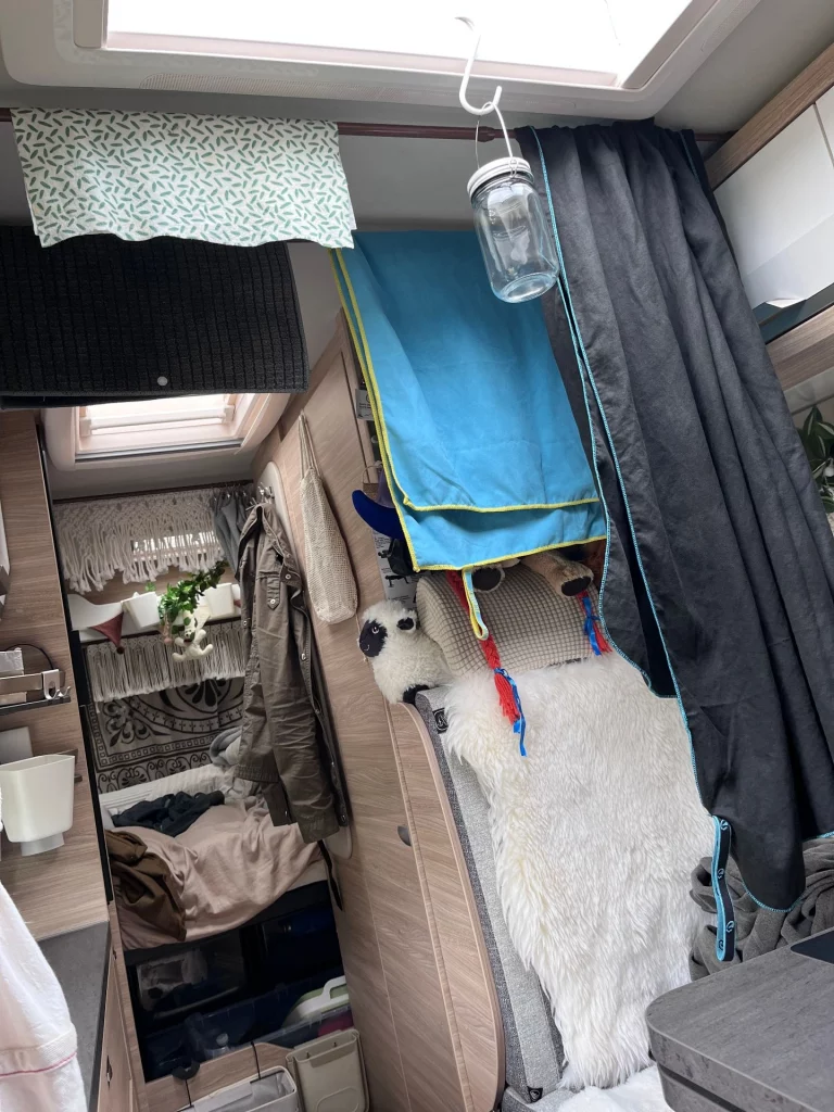 Blick in den Innenraum eines Knaus Boxlife Camper Vans, in dem Handtücher und Wäsche nach dem Duschen zum Trocknen aufgehängt sind.